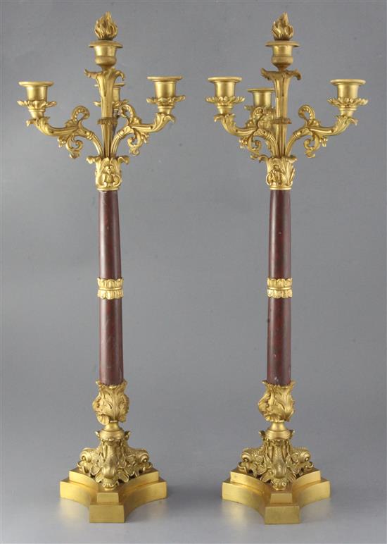 A pair of second quarter of the 19th century French ormolu and rouge marble four light candelabra, height 26.25in.